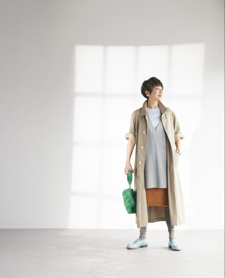 ニットベスト¥37,400／ポステレガント、中に着たタンクトップ¥13,200／チノ（モールド）、スカート¥97,900、コート¥179,300／ともにマディソンブルー、靴¥156,200／ジェイエムウエストン（ジェイエムウエストン 青山店）、バッグ¥36,300／リンク、ゴールドのイヤーカフ¥42,900、シルバーのイヤーカフ¥24,200／ともにコールムーン（ショールーム セッション）、ペンダント¥72,600／アリータ（ブルーベル・ジャパン ファッション事業本部）、バングル¥272,800／ソフィー ブハイ（エスケーパーズ アナザーワールド）、チェーンブレスレット¥25,300／シーエックスシー（アマン）、靴下／スタイリスト私物