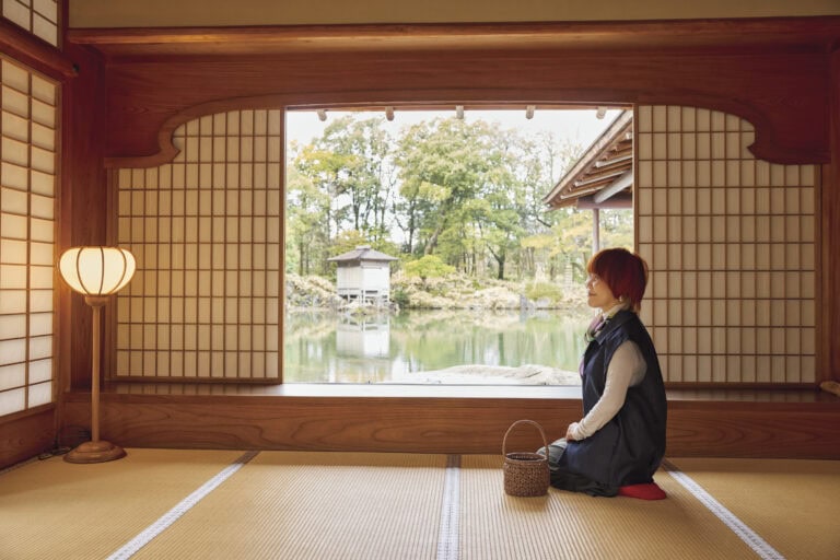 屋敷の見どころである御月見ノ間（おつきみのま）。座敷からの景色はすべて座って眺める前提で作られていると聞き、山本さんも座って。