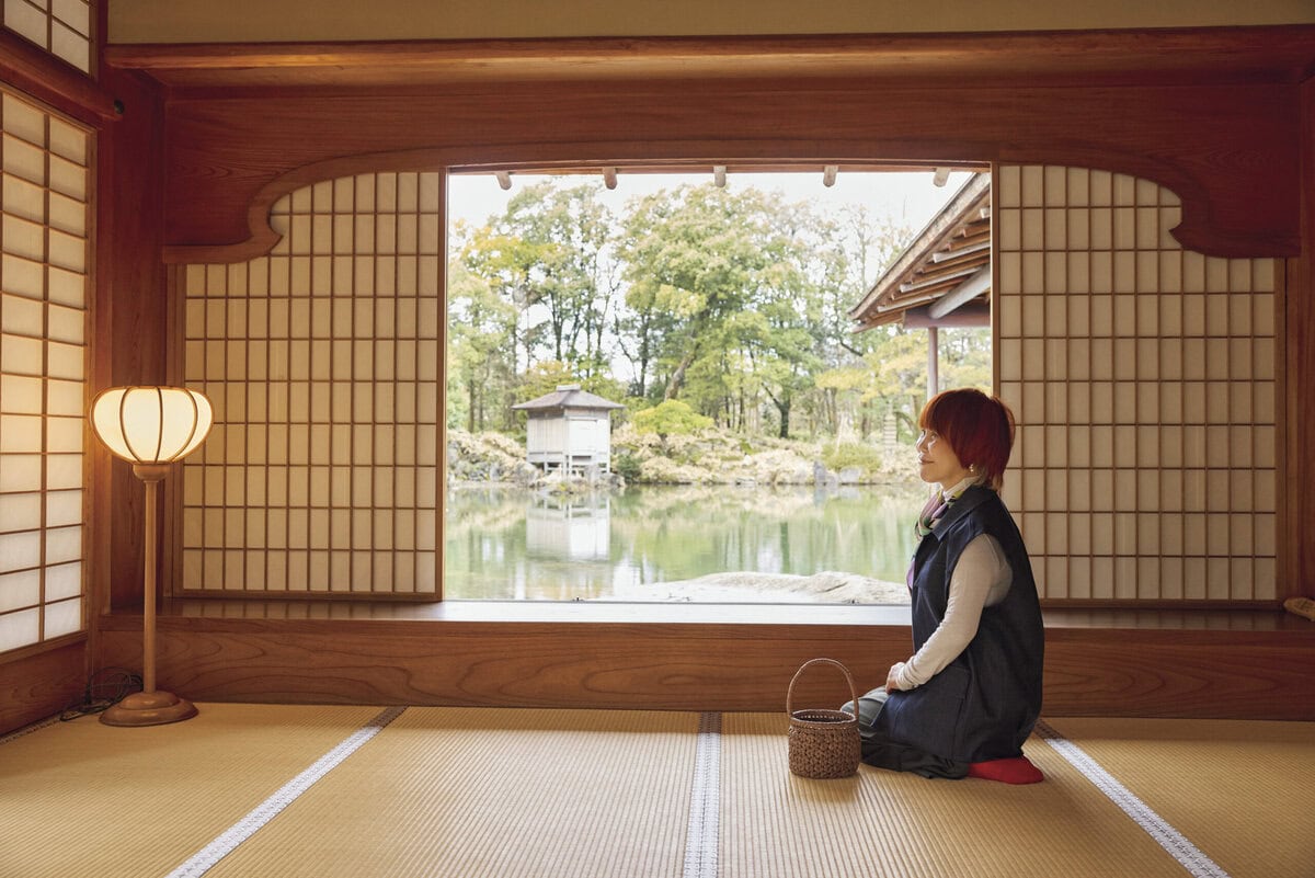 屋敷の見どころである御月見ノ間（おつきみのま）。座敷からの景色はすべて座って眺める前提で作られていると聞き、山本さんも座って。
