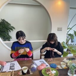 編み物に挑戦する若者2人