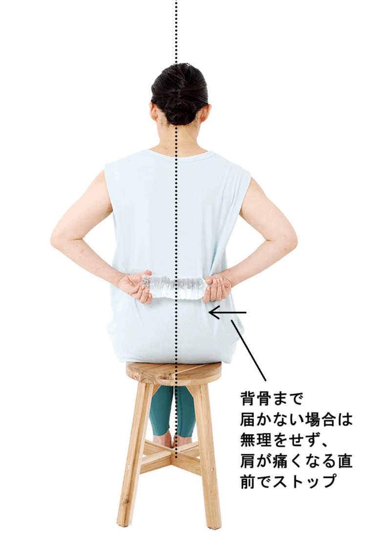 【2】肩が痛くないほうの手でペットボトルを横に引っ張り、背骨のラインに達したらその状態で10秒キープ。