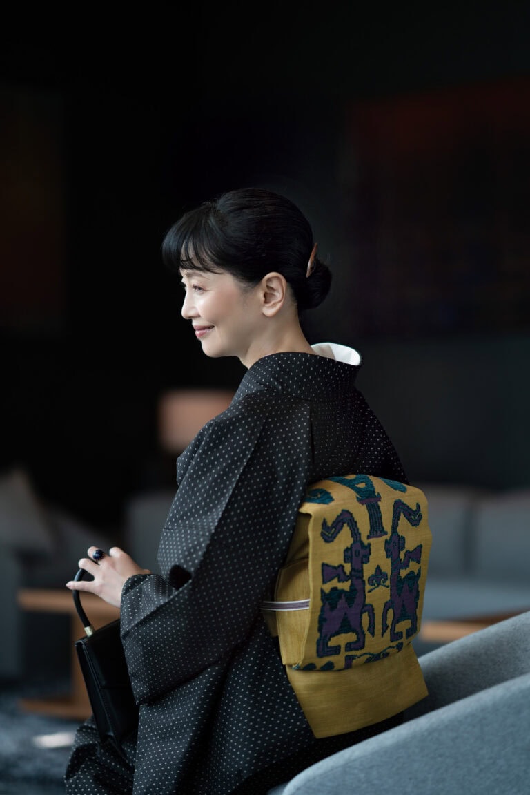 着物〈泥大島紬 一間長十字〉¥398,000（仕立て上がり）、帯¥318,000（仕立て上がり）、帯揚げ¥8,800、帯締め¥18,700／すべて銀座もとじ 和織・和染、バッグ¥80,300／タミーアンドベンジャミン、リング¥9,900／クロディーヌ・ヴィトリー（ともにアッシュ・ペー・フランス）、その他／スタイリスト私物