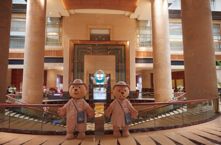 郵便局員の服を着たマスコットのテディベアがお出迎え。