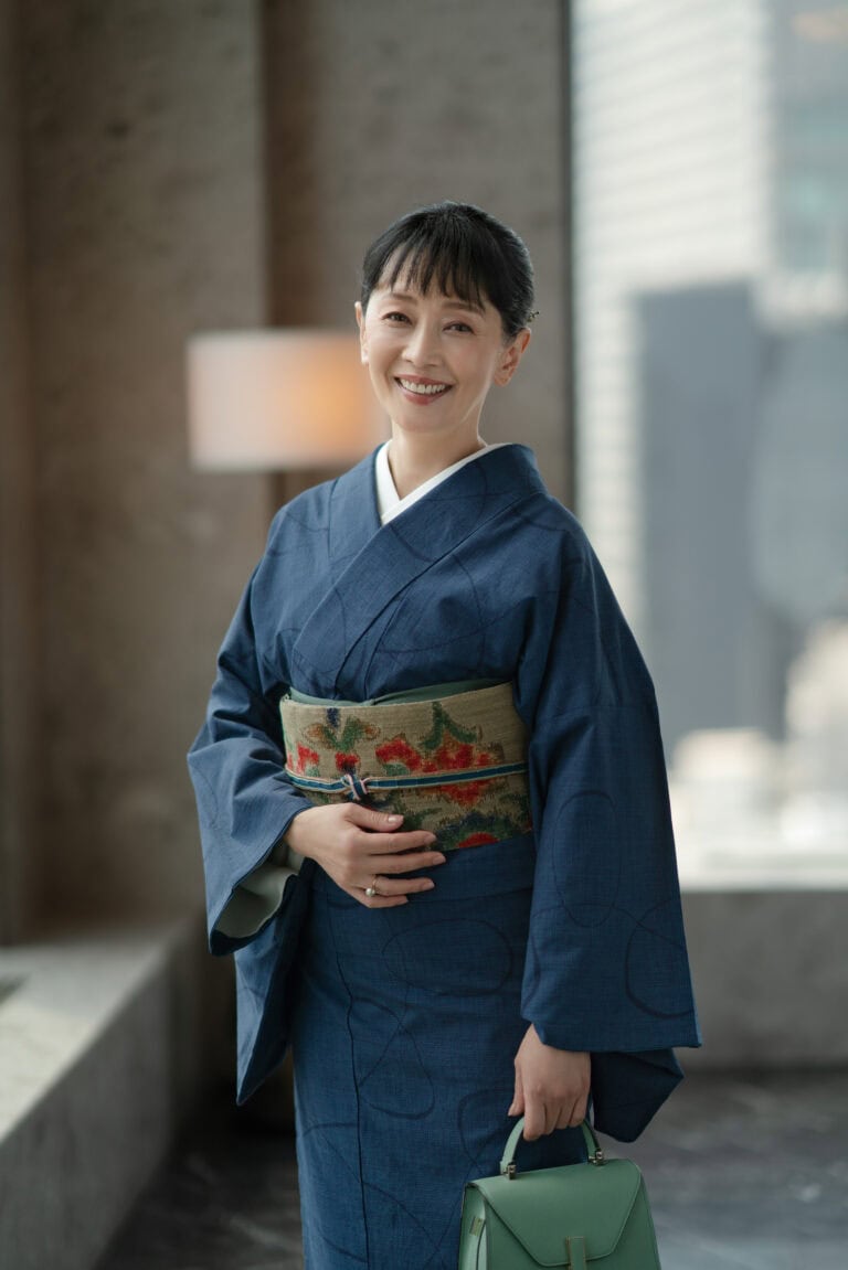 着物〈綿さつま 正藍「軌跡」〉¥780,000（仕立て上り）、帯¥380,000（仕立て上がり）、帯揚げ¥8,800、帯締め¥16,500／すべて銀座もとじ 和織・和染、リング¥157,300／ヒロタカ（ヒロタカ 表参道ヒルズ）、バッグ¥528,000／ヴァラクストラ（ヴァレクストラ・ジャパン）、その他／スタイリスト私物