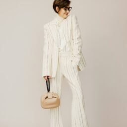 ジャケット¥623,700、中に着たタートルニット¥172,700、ブラウス¥289,300、パンツ¥334,400、バッグ¥506,000／すべて ガブリエラ ハースト（ガブリエラ ハースト ジャパン）、メガネ¥58,300／ユウイチ トヤマ（コンティニュエ）、ピアス¥53,400、リング〈右〉¥70,000／ともに トムウッド（トムウッド 青山店）、シューズ¥75,900／ホーガン（トッズ・ジャパン）