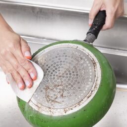 フライパン裏をこすってきれいにしているところ