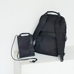 背面には、スーツケースの伸縮ハンドルにセットできるベルトつき。スマホが入るサコッシュもついています。