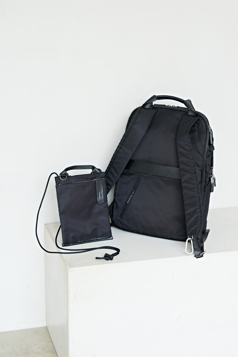 背面には、スーツケースの伸縮ハンドルにセットできるベルトつき。スマホが入るサコッシュもついています。