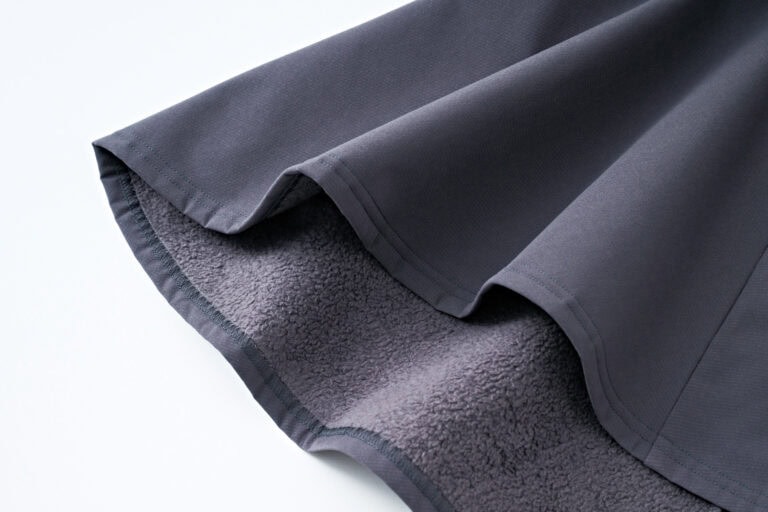 表地はドライタッチな素材、裏は温かみのあるフリースという二重織り構造。動きやすい4方向ストレッチも◎。