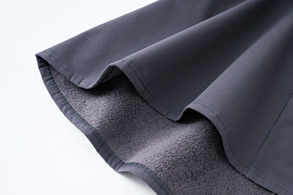 表地はドライタッチな素材、裏は温かみのあるフリースという二重織り構造。動きやすい4方向ストレッチも◎。