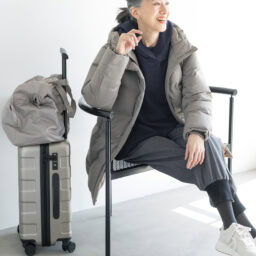 ダウンコート¥17,900／ユニクロ、中に着たクルーネックT¥2,290／ユニクロ：シー（ユニクロ）、ブラウス¥75,900／デ・ドゥエ（アッシュ・ペー・フランス）、パンツ¥47,300／エズミ（リ デザイン）、スニーカー¥35,200／ノーネーム（ストックマン）、ボストンバッグ¥2,990、キャリーケース¥19,900／ともに無印良品（無印良品 銀座）、タイツ／スタイリスト私物