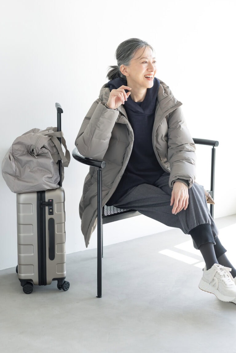 ダウンコート¥17,900/ユニクロ、中に着たクルーネックT¥2,290/ユニクロ:シー(ユニクロ)、ブラウス¥75,900/デ・ドゥエ(アッシュ・ペー・フランス)、パンツ¥47,300/エズミ(リ デザイン)、スニーカー¥35,200/ノーネーム(ストックマン)、ボストンバッグ¥2,990、キャリーケース¥19,900/ともに無印良品(無印良品 銀座)、タイツ/スタイリスト私物