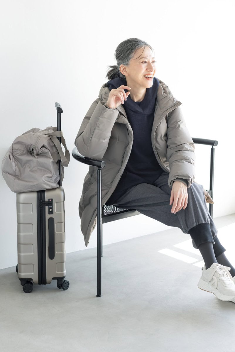 ダウンコート¥17,900/ユニクロ、中に着たクルーネックT¥2,290/ユニクロ:シー(ユニクロ)、ブラウス¥75,900/デ・ドゥエ(アッシュ・ペー・フランス)、パンツ¥47,300/エズミ(リ デザイン)、スニーカー¥35,200/ノーネーム(ストックマン)、ボストンバッグ¥2,990、キャリーケース¥19,900/ともに無印良品(無印良品 銀座)、タイツ/スタイリスト私物