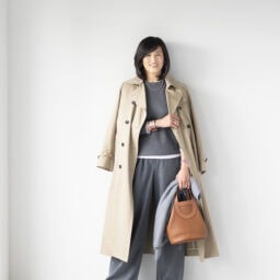 コート／イエナ、ニット、ロングスリーブTシャツ／ともにユニクロ、パンツ／ザラ、イヤリング／ノーブランド、ボールネックレス／アメリ、ゴールドネックレス／インポートブランド、バングル、バッグ／ともにエルメス、時計／ロレックス、リング（左手）／ティファニー、リング（右手）／チエコプラス、手に持ったストール／バーニーズ ニューヨーク、スニーカー／スティーブン・マデン（すべて私物）