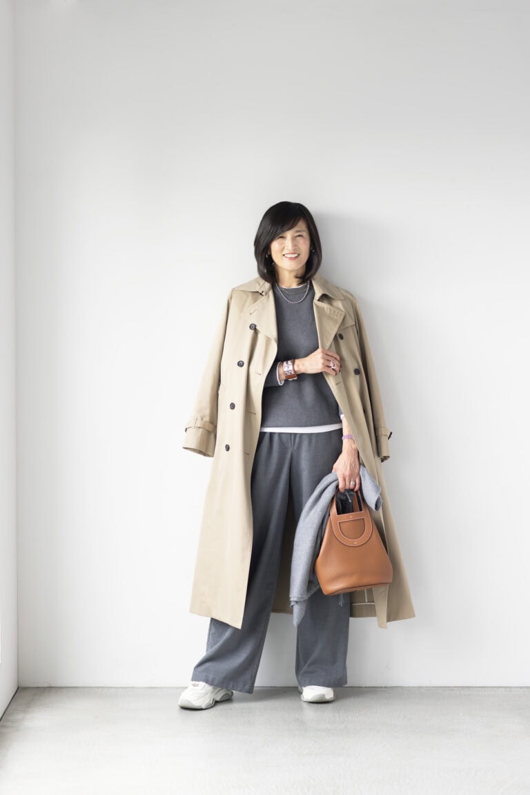 コート/イエナ、ニット、ロングスリーブTシャツ/ともにユニクロ、パンツ/ザラ、イヤリング/ノーブランド、ボールネックレス/アメリ、ゴールドネックレス/インポートブランド、バングル、バッグ/ともにエルメス、時計/ロレックス、リング(左手)/ティファニー、リング(右手)/チエコプラス、手に持ったストール/バーニーズ ニューヨーク、スニーカー/スティーブン・マデン(すべて私物)