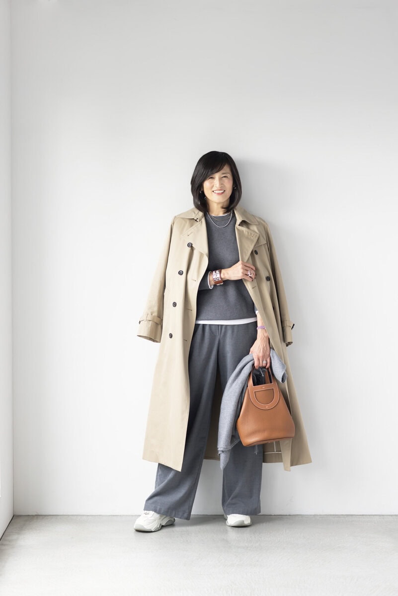 コート／イエナ、ニット、ロングスリーブTシャツ／ともにユニクロ、パンツ／ザラ、イヤリング／ノーブランド、ボールネックレス／アメリ、ゴールドネックレス／インポートブランド、バングル、バッグ／ともにエルメス、時計／ロレックス、リング（左手）／ティファニー、リング（右手）／チエコプラス、手に持ったストール／バーニーズ ニューヨーク、スニーカー／スティーブン・マデン（すべて私物）