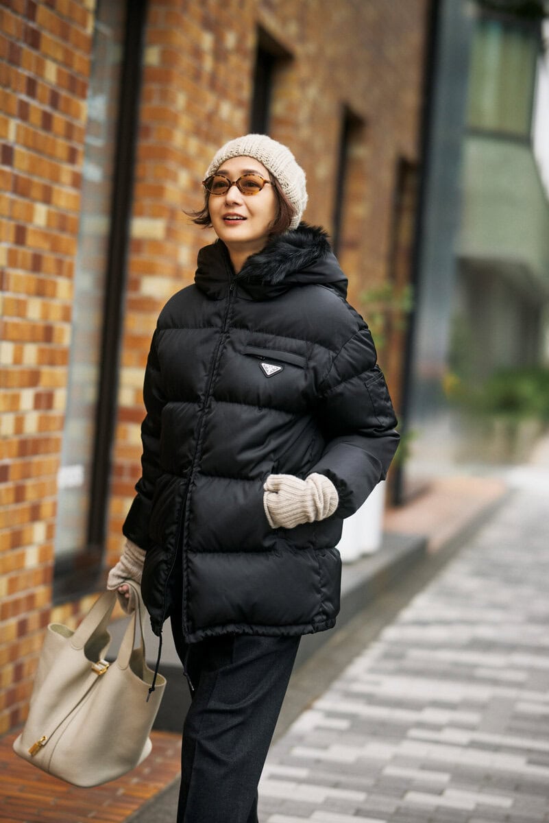 ダウン：プラダ、パンツ：セリーヌ、ニット帽：サラ ルナ、サングラス：ミュウ ミュウ、グローブ：アルジット、バッグ：エルメス