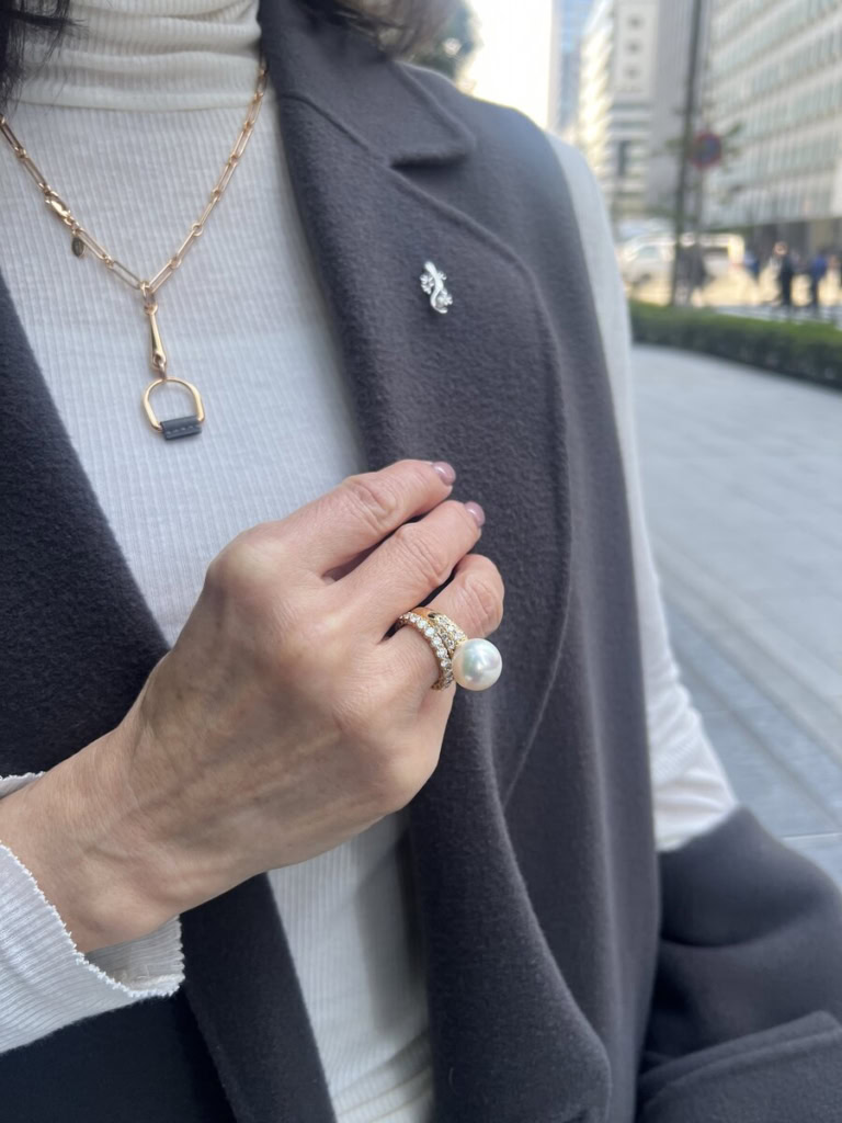 「コーデ全体はクールな雰囲気にしたので、華やかなアクセサリーでエレガントな雰囲気に。大人遊びを効かせたヤモリのピンブローチは小さなパールがついていて、大ぶりなパールのリングとリンク。ゴールドのネックレスは、トップにグレーのレザーがあしらわれているので、ジレ&コートやバッグとリンクさせ、コーディネートに統一感を持たせています」