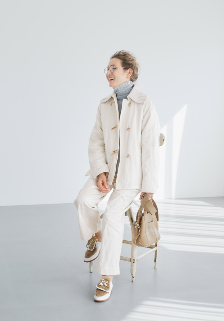 ショート丈コート¥495,000、パンツ¥217,800、中に着たタートルネックニット¥209,000/すべてチヴィディーニ(コロネット)、メガネ¥77,880/ハフマンス&ノイマイスター(コンティニュエ)、ピアス¥43,100、リング¥54,200/ともにトムウッド(トムウッド 青山店)、バッグ¥88,330/ホーガン(トッズ・ジャパン)、シューズ¥83,600/ネブローニ