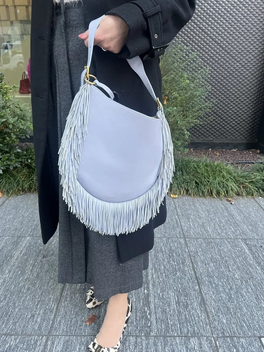 「J&M DAVIDSONで人気の巾着バッグを買いに行くつもりが、斜めがけにもハンドル持ちもできて、かしこまった場だけでなくカジュアルなシーンにも使えると思って購入したバッグです。細かく繊細に揺れるフリンジがキレイで、コーデのアクセントとして投入しました」