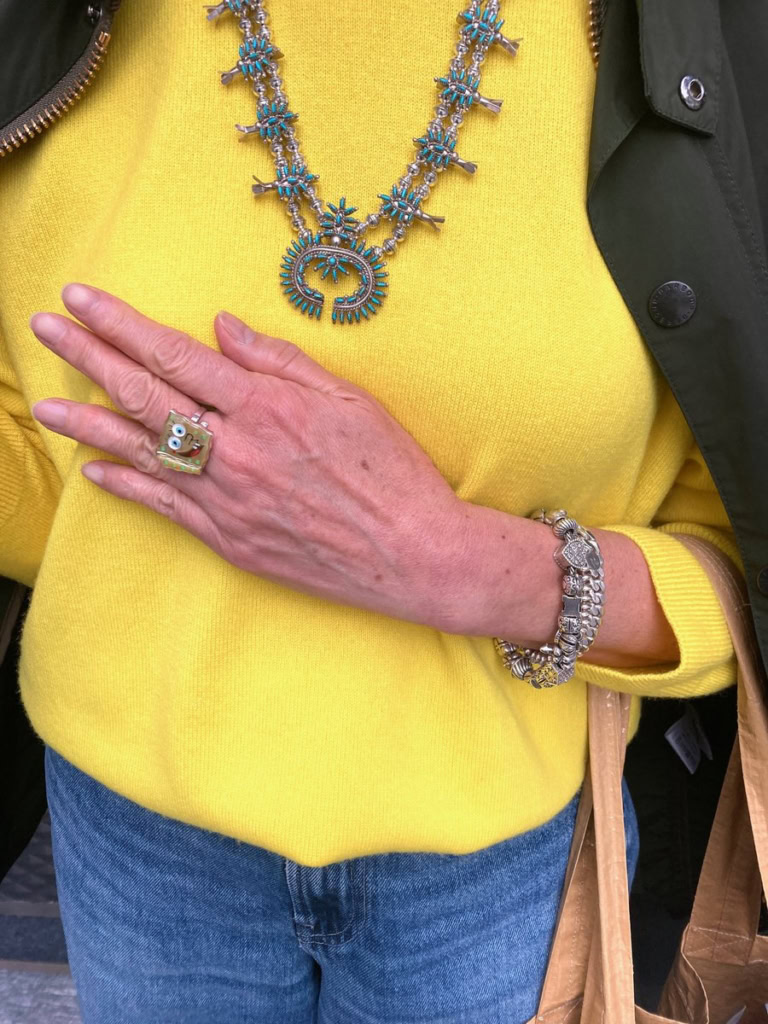 「ネックレスは黄色と好相性のターコイズのネックレスでリュクス感をコーデにプラス。スポンジボブのリングもニットに合わせて。あえてキャラクターのリングを選び、遊んでみました」