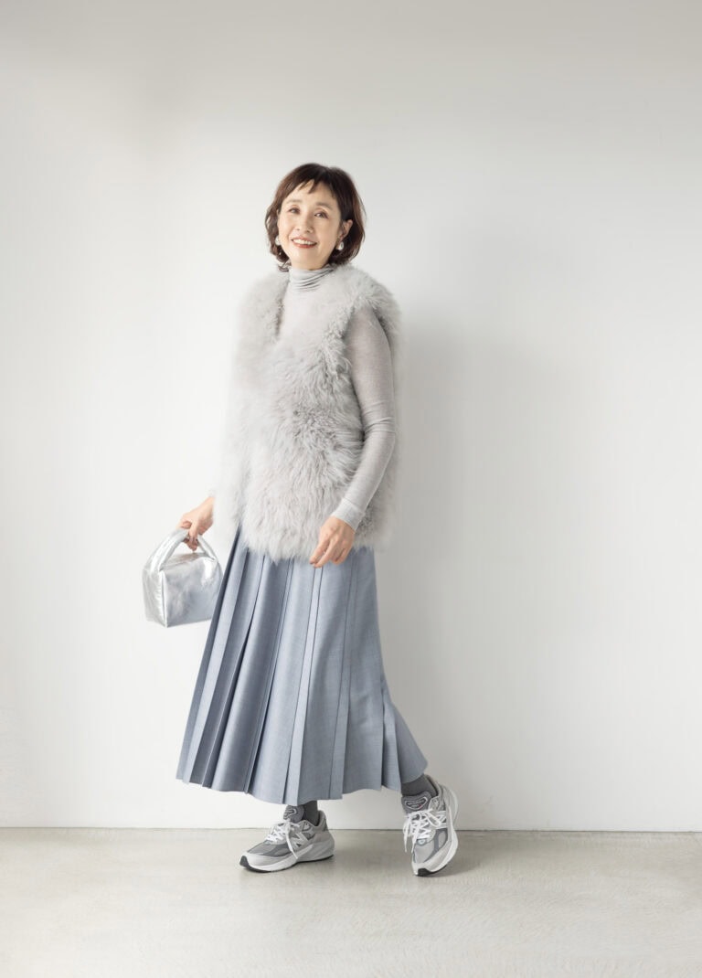 タイツ¥2,640/靴下屋(タビオ)、ジレ(一部店舗限定)¥319,000、スカート¥69,300/ともにエブール(リトルリーグ インク)、タートルネック¥11,000/ソージュ(ソージュ オンラインストア)、バッグ¥39,600/バケット バゲージ(アイネックス)、イヤリング¥8,800/アビステ、靴¥39,600/ニューバランス(ニューバランスジャパンお客様相談室)