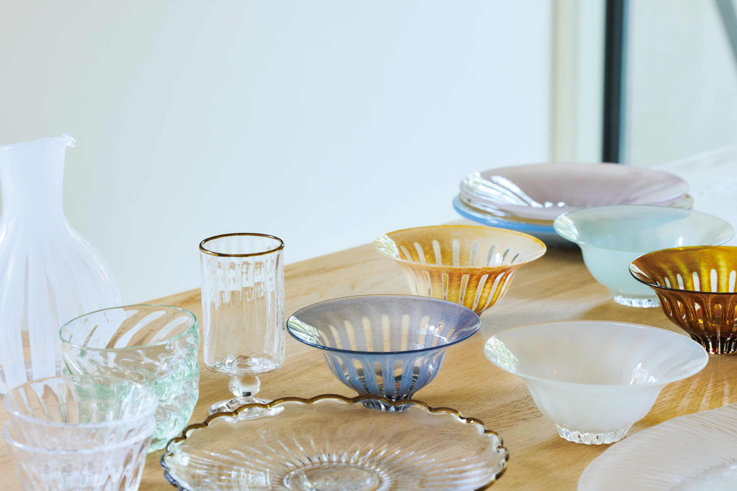 スモーキーな色合いの器はすべて花岡央(ひろい)さんの作品。「器店“千鳥”で出合い、絶妙な色合いにひと目惚れ。平皿や鉢、花器などいろいろと集めています」。キラキラ輝くガラスは食材をみずみずしく見せ、四季を問わず活躍しているそう。茶色の縁がしゃれた器は田井将博(たいまさひろ)さんの作品。「グラスは“カフェオレグラス”という名前で、確かにカフェオレがよく似合います」