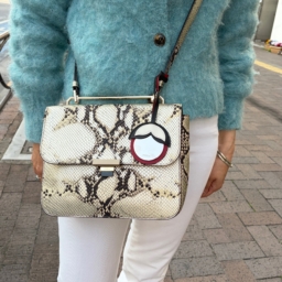 バッグは「フルラ」。「柄の入った服をあまり着ないので、バッグで遊び心を出しています。上品なパイソン柄なので、シンプルなコーデのポイントになってくれるんです。荷物も意外と入るので実用的にも優秀。チャームはミラーになっていて、リップ直しにも便利です」