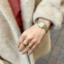 時計とリングは「カルティエ」で揃えて。「手元のさりげない輝きが、スタイリング全体に気品を添えてくれます。ベージュのコートにも相性がいいかなと思い、ゴールドメインで合わせました」