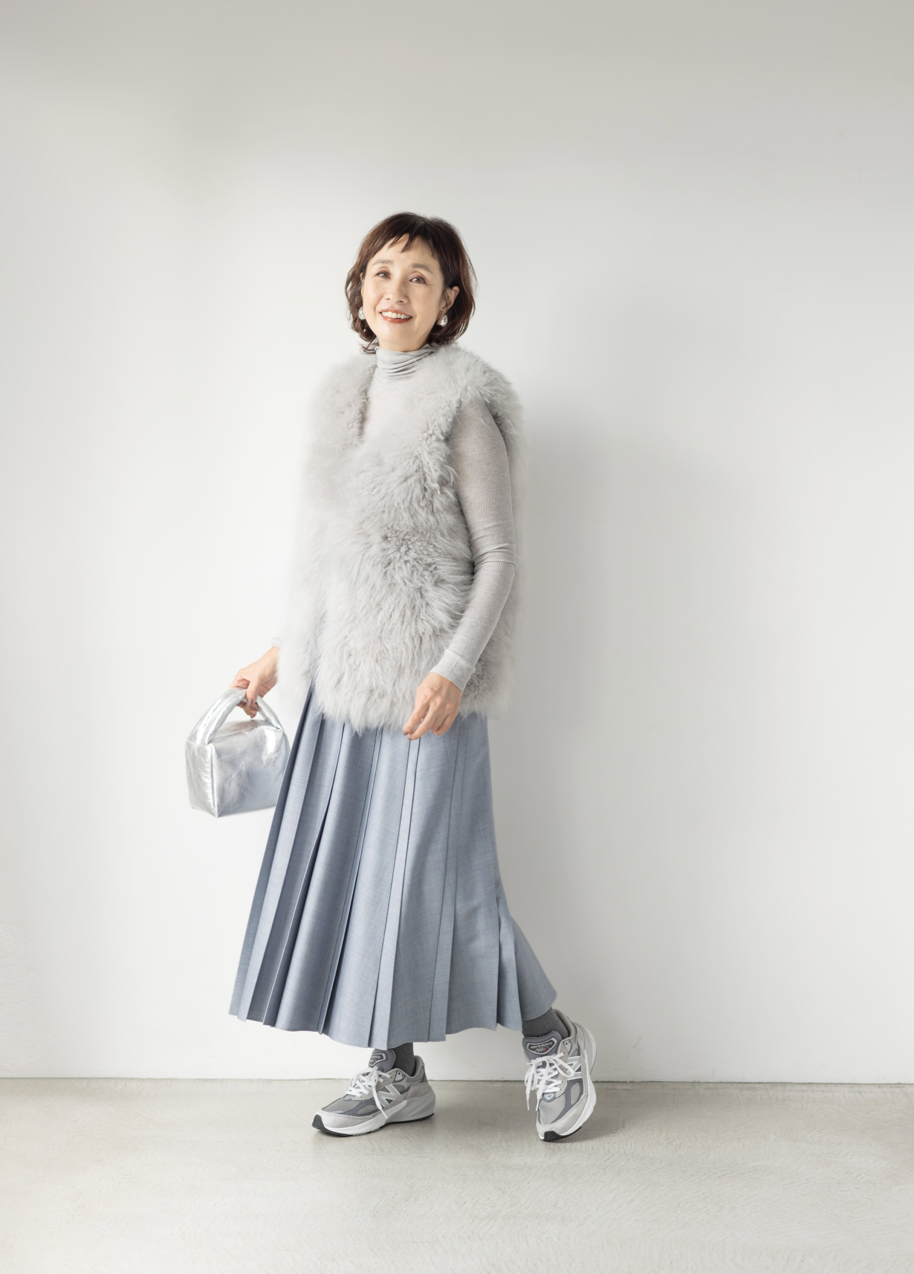 タイツ¥2,640／靴下屋（タビオ）、ジレ（一部店舗限定）¥319,000、スカート¥69,300／ともにエブール（リトルリーグ インク）、タートルネック¥11,000／ソージュ（ソージュ オンラインストア）、バッグ¥39,600／バケット バゲージ（アイネックス）、イヤリング¥8,800／アビステ、靴¥39,600／ニューバランス（ニューバランスジャパンお客様相談室）