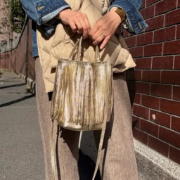 伝統的なイタリアの革製品ブランド「マーロンフィレンツェ」のゴールドカラーのバッグは、ストールのベージュとも自然に馴染み、登場回数が多いそう。「ボリューム感のあるストールに対して、胸元のアクセサリーはあえて入れず、フリンジバッグをアクセサリー代わりに持ちました。デイリーに使いやすい柔らかな革質も魅力です」