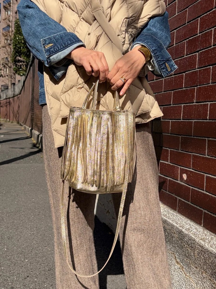 伝統的なイタリアの革製品ブランド「マーロンフィレンツェ」のゴールドカラーのバッグは、ストールのベージュとも自然に馴染み、登場回数が多いそう。「ボリューム感のあるストールに対して、胸元のアクセサリーはあえて入れず、フリンジバッグをアクセサリー代わりに持ちました。デイリーに使いやすい柔らかな革質も魅力です」