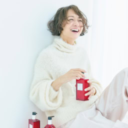 〈床置き右から〉「オー ドゥ ルバーブ エルカラット」ハンド＆ボディ クレンジングジェル¥11,110、同 ヘア＆ボディ シャワージェル¥11,000、〈手に持ったボトル〉同 モイスチャライジング ボディローション¥12,650／すべてエルメス（エルメスジャポン）、ニット¥39,600／カオス（Chaos GINZA SIX）、パンツ※参考商品／デパリエ（デパリエ 伊勢丹新宿店）、ピアス¥40,000／トムウッド（トムウッド 青山店）