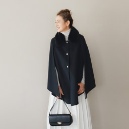 マント¥187,000／エルマンノ フェレンツェ、ニット¥132,000、スカート¥170,500／ともにジェントリー ポルトフィーノ（すべてウールン商会）、ピアス¥233,200 、リング（薬指）¥176,000、リング（小指）¥299,200／すべてプライマル、バッグ¥59,400 ／マエストソ（アマン）、シューズ¥97,900／ペリーコ（アマン）