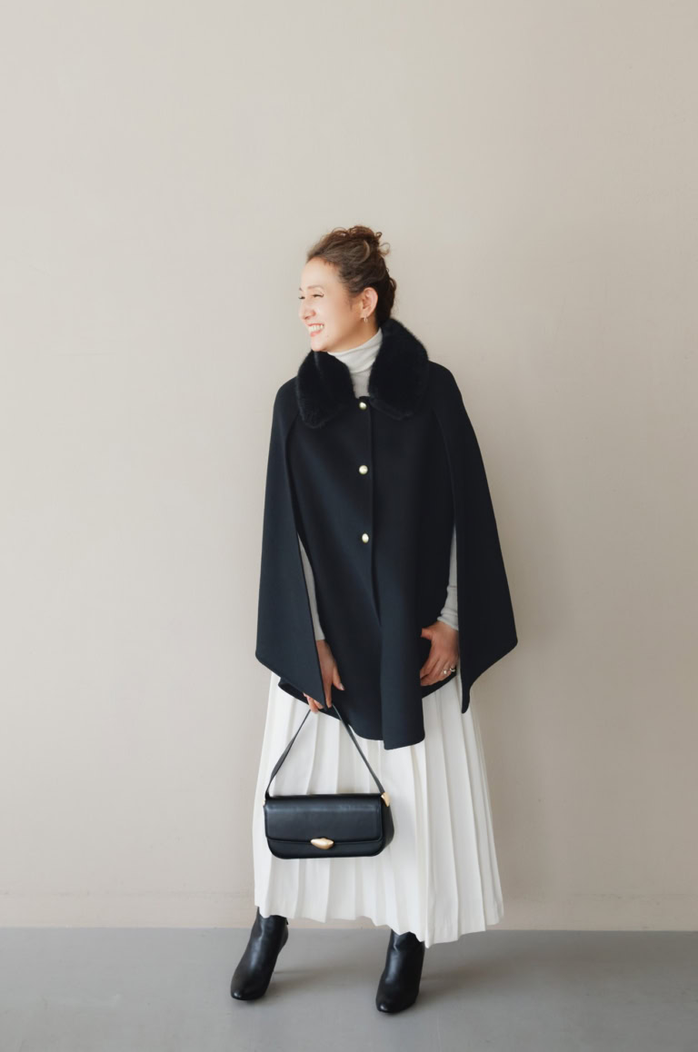 マント¥187,000/エルマンノ フェレンツェ、ニット¥132,000、スカート¥170,500/ともにジェントリー ポルトフィーノ(すべてウールン商会)、ピアス¥233,200 、リング(薬指)¥176,000、リング(小指)¥299,200/すべてプライマル、バッグ¥59,400 /マエストソ(アマン)、シューズ¥97,900/ペリーコ(アマン)