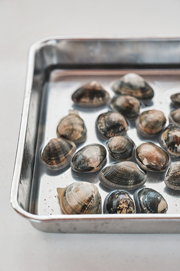 砂抜きが必要な場合は、あさりが少し出るくらいの塩水(塩分濃度約3%)に浸して新聞紙などをのせ、常温に1〜2時間おいて