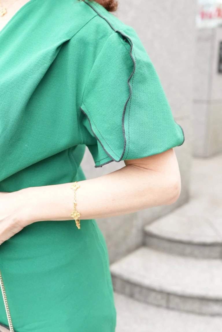 「構築的で揺れ感が綺麗なパフスリーブはネイビーのパイピングでシルエットが強調され、華やか。気になりがちな二の腕をすっきり見せてくれるのも嬉しいポイントです」