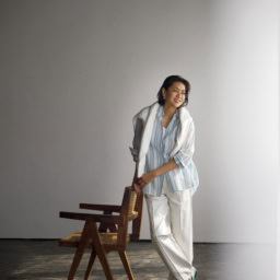 シャツ¥104,500／アッシュ（コロネット）、肩にかけたニット¥64,900、パンツ¥53,900／ともにドゥロワー（ドゥロワー 青山店）、タンクトップ／スタイリスト私物、ピアス¥47,300／ウノアエレ シルバーコレクション（ウノアエレ ジャパ ン）、靴¥115,500／セルジオ ロッシ （セルジオ ロッシ ジャパン カスタマーサービス）