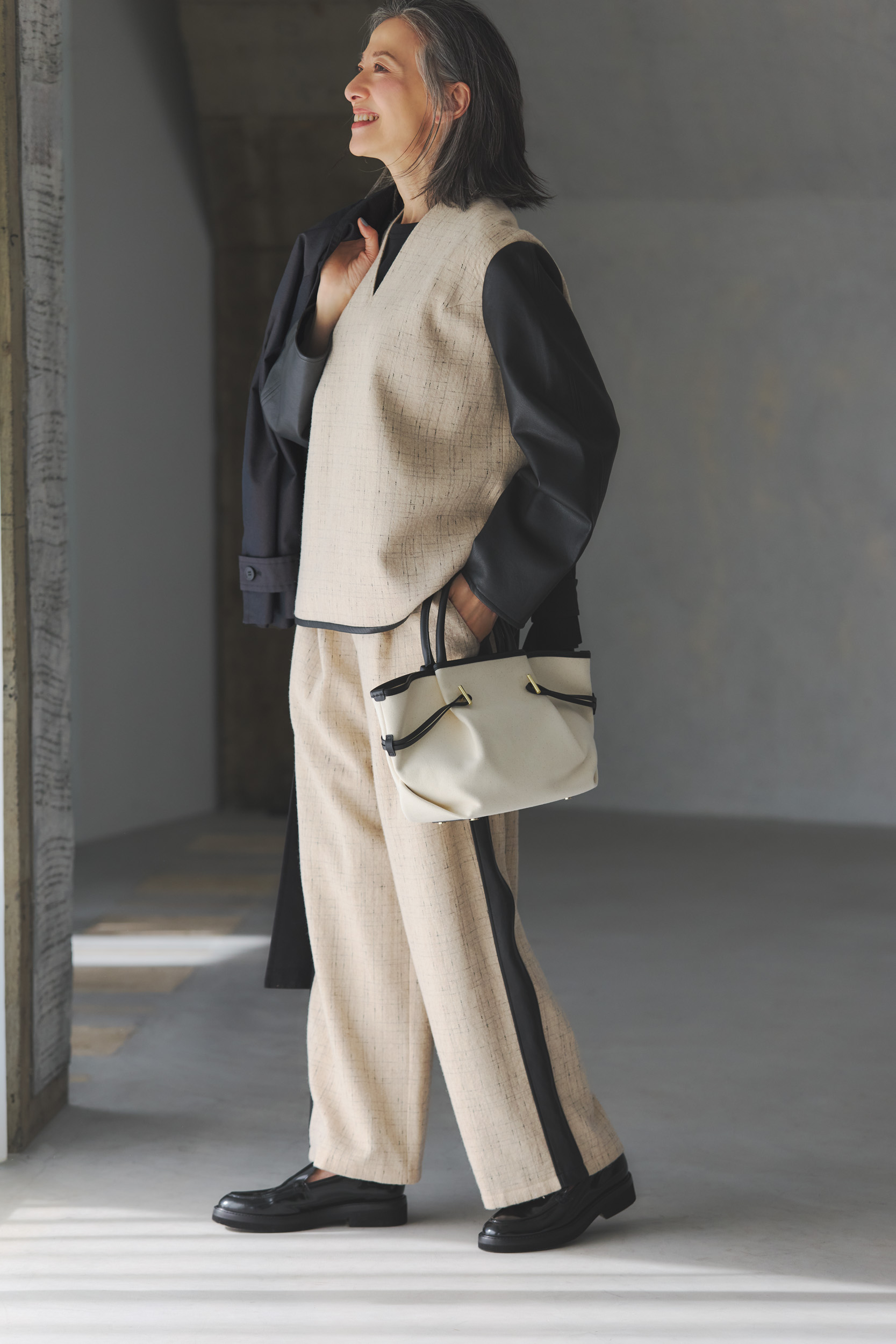 ブラウス¥40,700、パンツ¥45,100／ともにグリードインターナショナル、手に持ったコート¥110,000／コラム（エストネーション）、バッグ¥30,800／サムウェア ステュディオ（リンク・セオリー・ジャパン）、Tシャツ、シューズ／スタイリスト私物