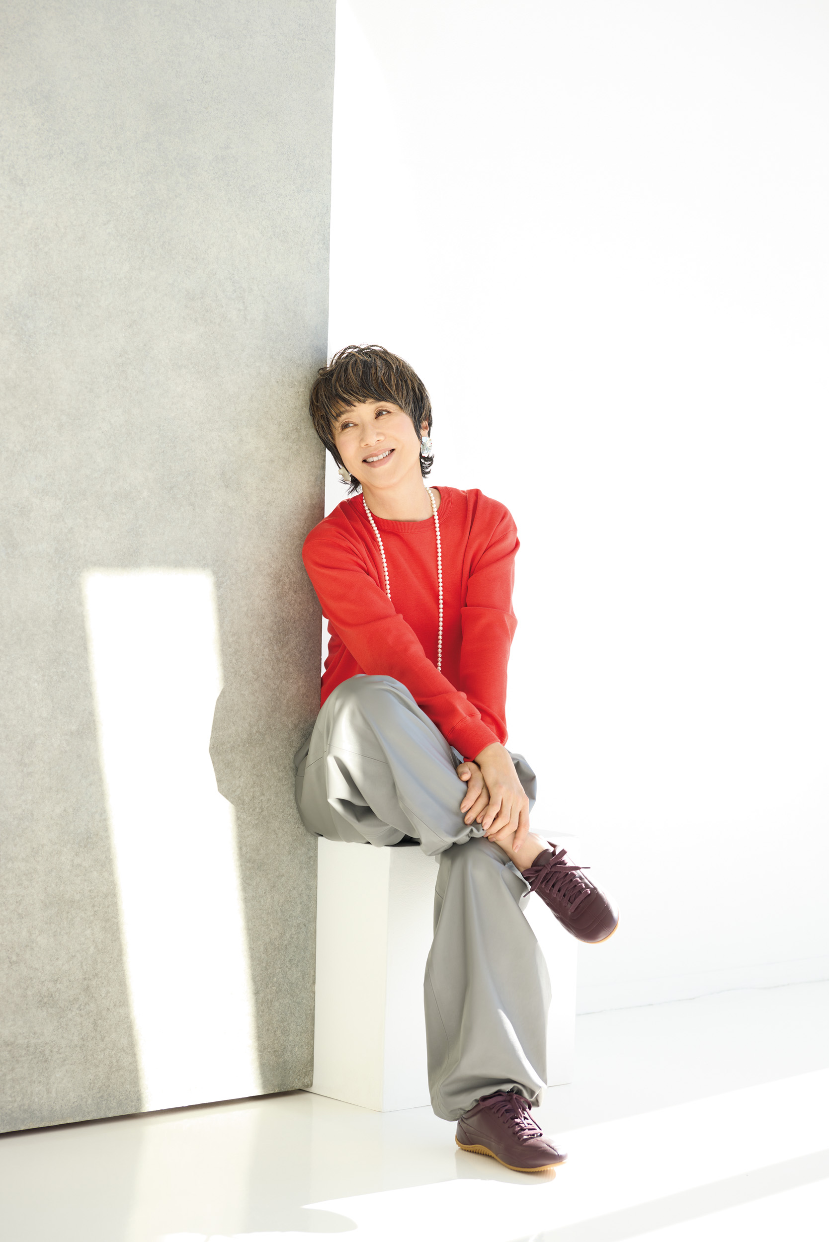 ニット¥42,900、パンツ¥187,000／ともにエブール（リトルリーグ インク）、スニーカー¥70,400／ロンシャン（ロンシャン・ジャパン）、ネックレス［参考商品］／マディソンブルー、ピアス¥34,100／プリュイ（プリュイ トウキョウ）