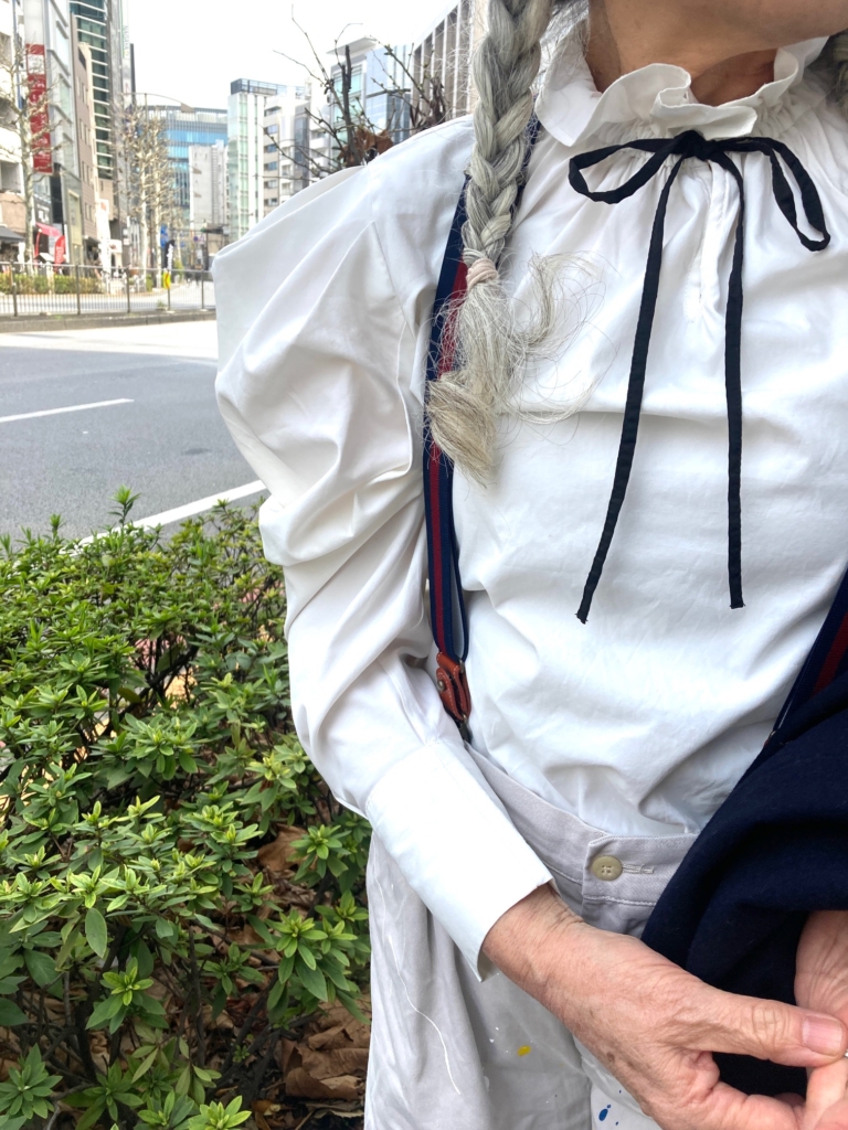 「インナーのブラウスは肩まわりのフォルムが構築的。１枚で着ても着映えるアイテムで重宝しています。首元には黒のボウタイでフェミニンながらも知的なアクセントとしてプラスしています」