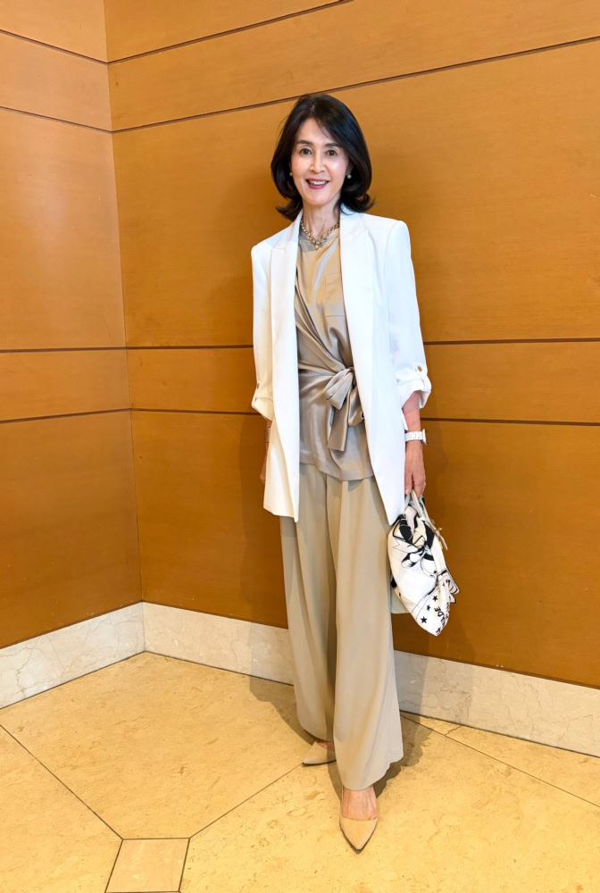 【60代街角スナップ】主役は「マックスマーラ」のリボンシャツ!「エルメス」のバッグとスカーフの差し色で叶える、上品な淡色コーデ