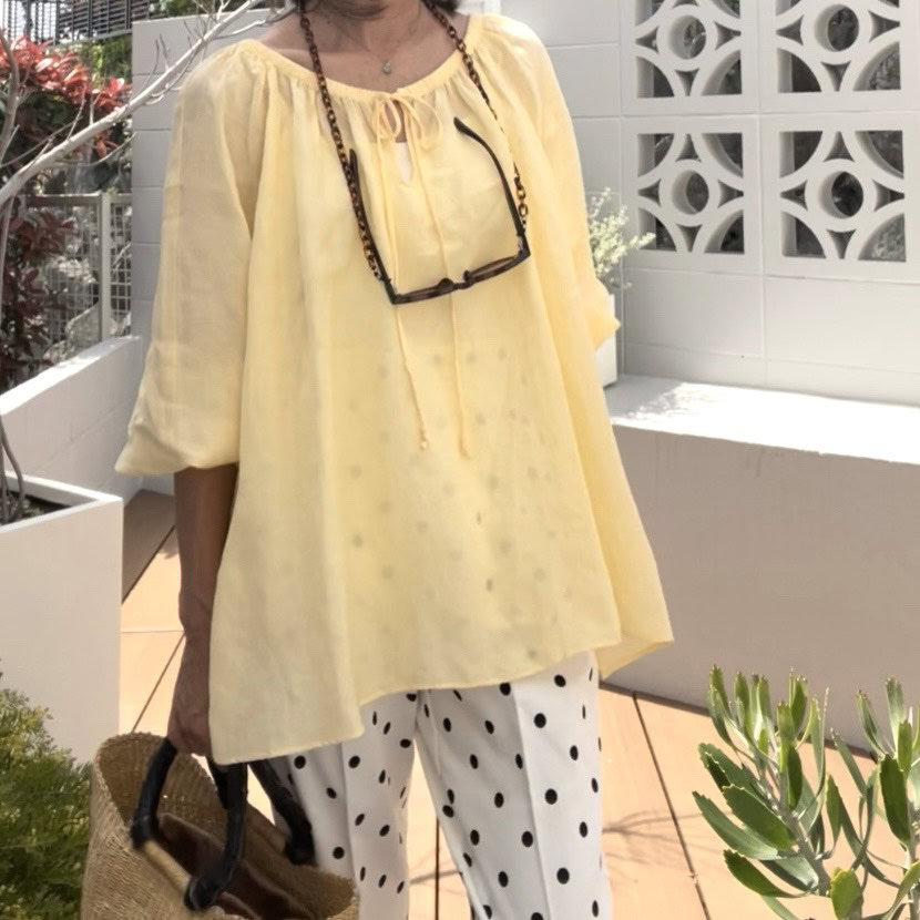 明るくフェミニンなトップスでリゾート気分を上げて