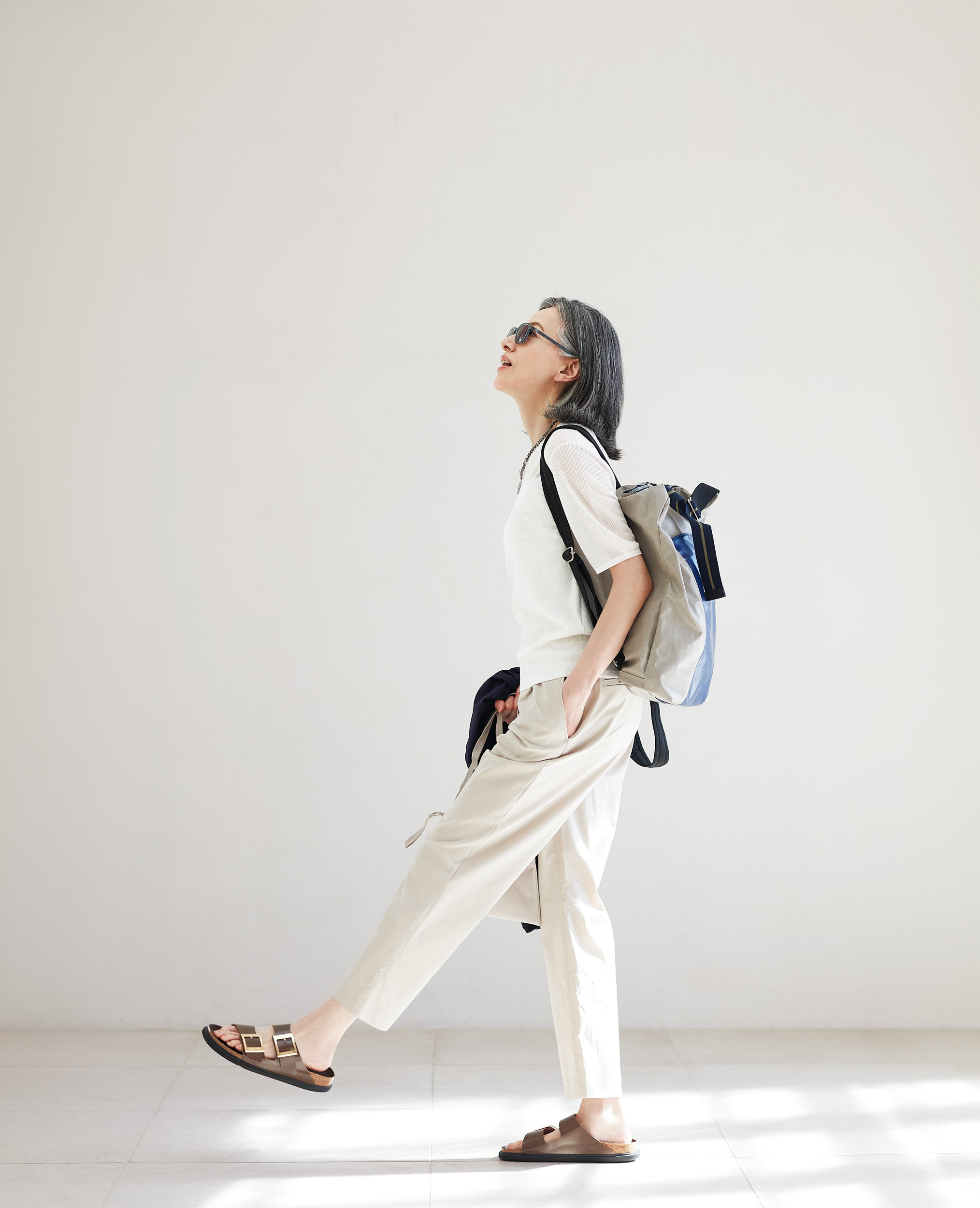 サコッシュ¥1,490、手に持ったパーカ［4月中旬発売予定］¥4,990、／ともに無印良品（無印良品 銀座）、ニットトップス¥7,990、パンツ¥9,990／ともにプラステ、サングラス¥77,000／リンドバーグ（ケリング アイウエア ジャパン カスタマーサービス）、ネックレス¥59,400／ジェム・キングダム、リュック¥48,400／ジャック･ゴム（ともにアッシュ・ペー・フランス）、サンダル¥33, 000／ビルケンシュトック（ビルケンシュトック・ジャパン  カスタマーサービス ）