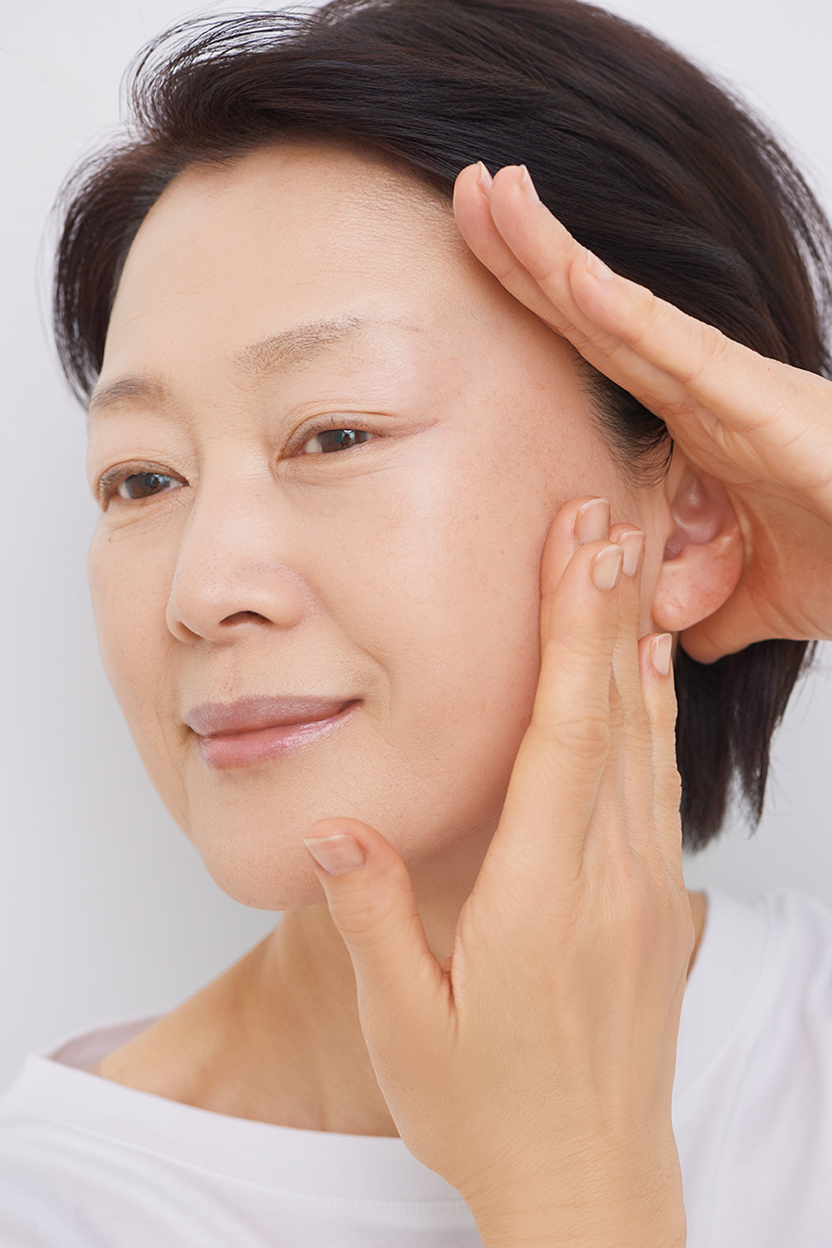 片手を生え際に置き、肌をぐっと引き上げて伸ばし、フェイスラインに下地やファンデを塗ります。下がりがちな頰に塗る際も同様に。