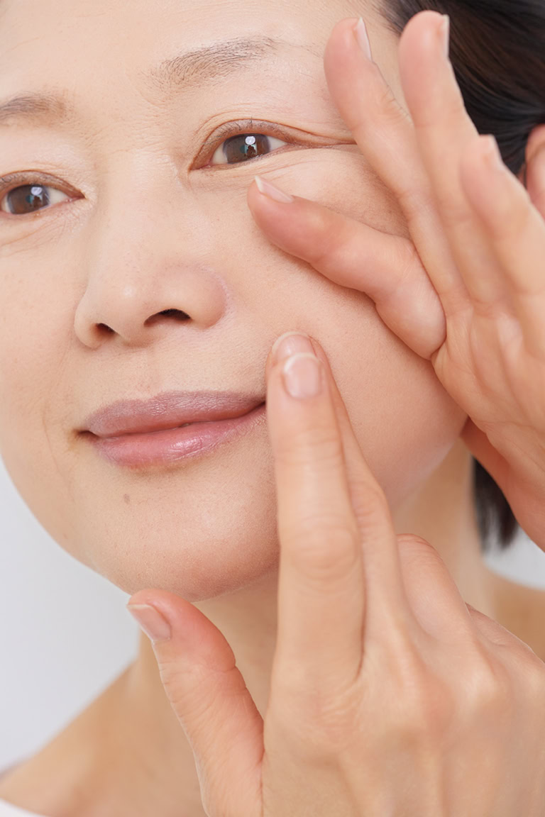 頰に指を置き、ほうれい線の溝を伸ばして平らにして、下地やファンデをなじませます。マリオネットラインや目の下のシワの部分にも伸ばして塗って。