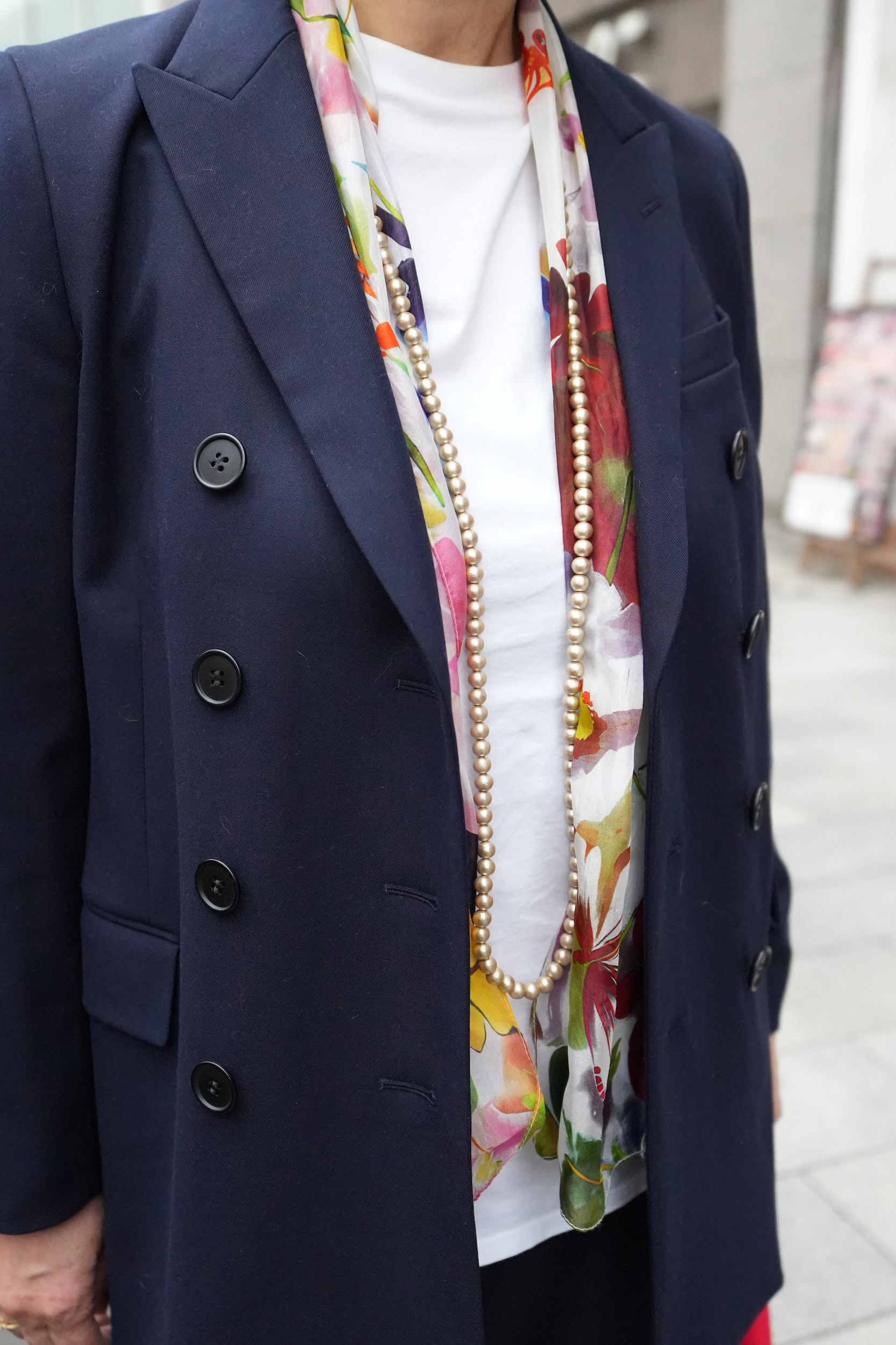 「スーツはともするとビジネスライクにも見えてしまうので、カラフルな花柄のスカーフとパールのロングネックレスをプラス。やわらかくエレガントな印象に仕上がります」