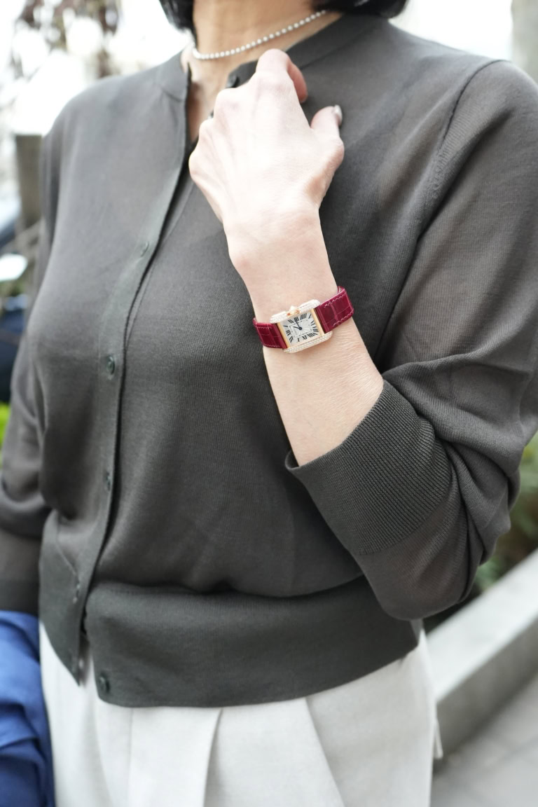 「腕時計の赤いレザーベルトとゴールドの輝きは、落ち着いた色味の服に合わせると目を引くポイントに。ブレスレットなど他のジュエリーをレイヤードしなくても優美な手元に仕上げてくれます」