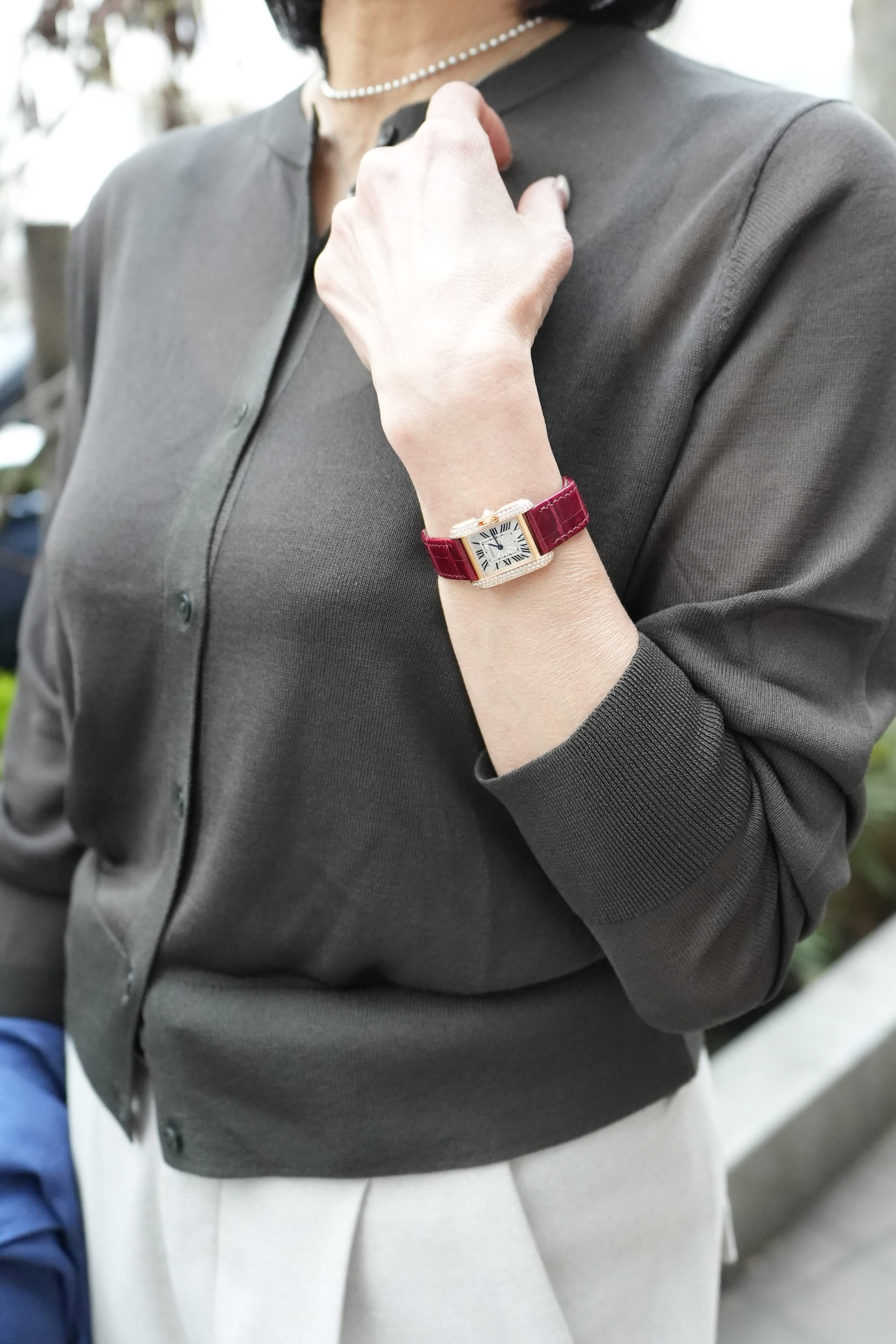 「腕時計の赤いレザーベルトとゴールドの輝きは、落ち着いた色味の服に合わせると目を引くポイントに。ブレスレットなど他のジュエリーをレイヤードしなくても優美な手元に仕上げてくれます」