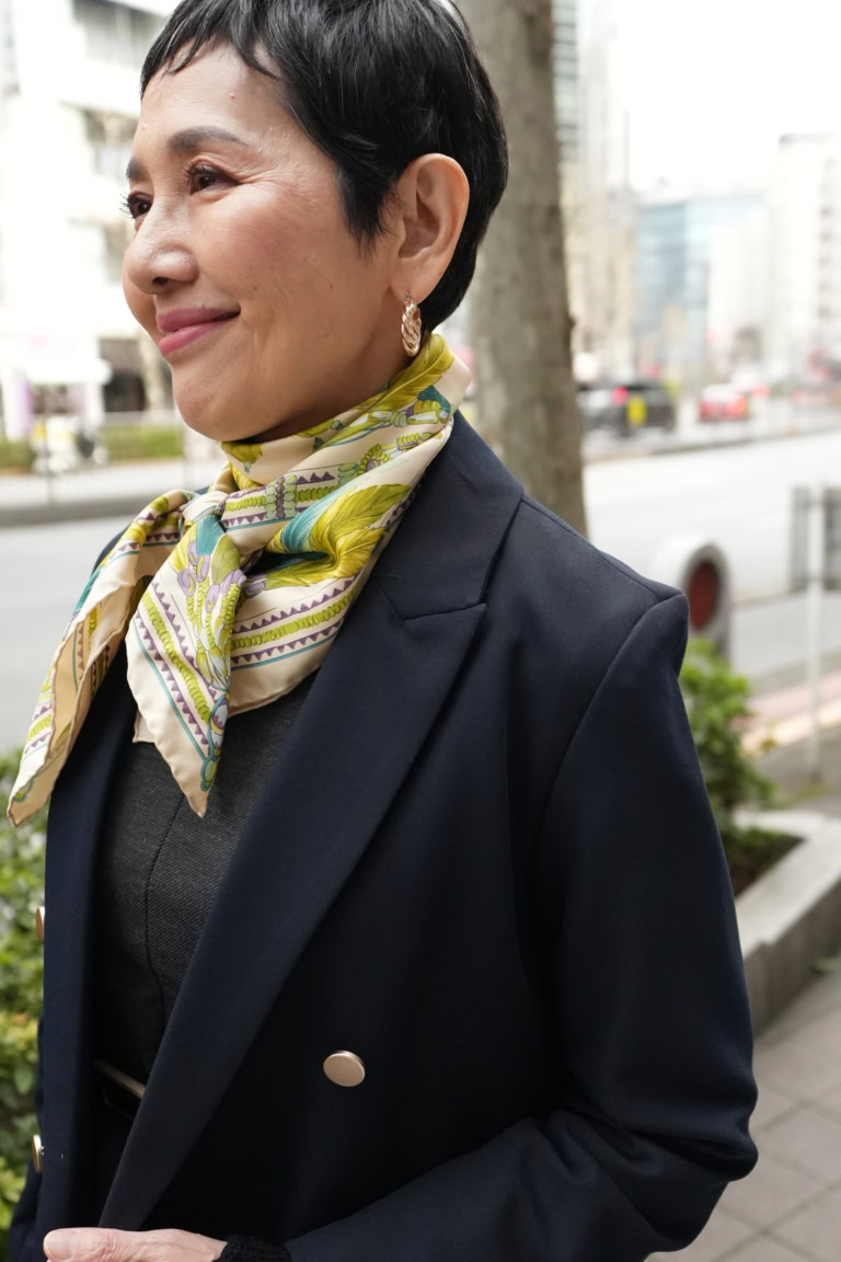 「ネイビーにグレーなどダークカラーがメインなので首元は春らしい鮮やかなカラーのスカーフを。顔まわりが品よく華やかにキマる上に、視線を首元に集めることですらりとしたシルエットを強調することもできます」